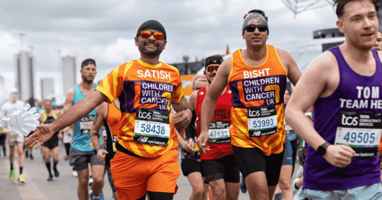Dos hombres corriendo con la camiseta naranja de la fundación Children With Cancer.