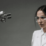 Científica y asistente de laboratorio trabajando junto a un brazo robótico con inteligencia artificial.