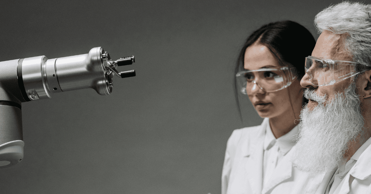 Científica y asistente de laboratorio trabajando junto a un brazo robótico con inteligencia artificial.