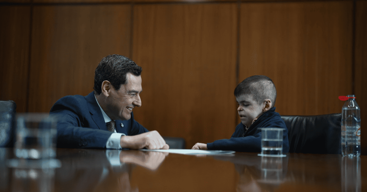 Leo con un hombre sentados en una mesa.