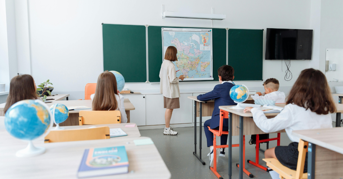 Estudiantes y maestro en un aula de clases.