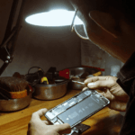 Un hombre reparando un móvil.