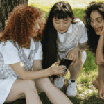 Tres adolescentes obserdando el móvil.