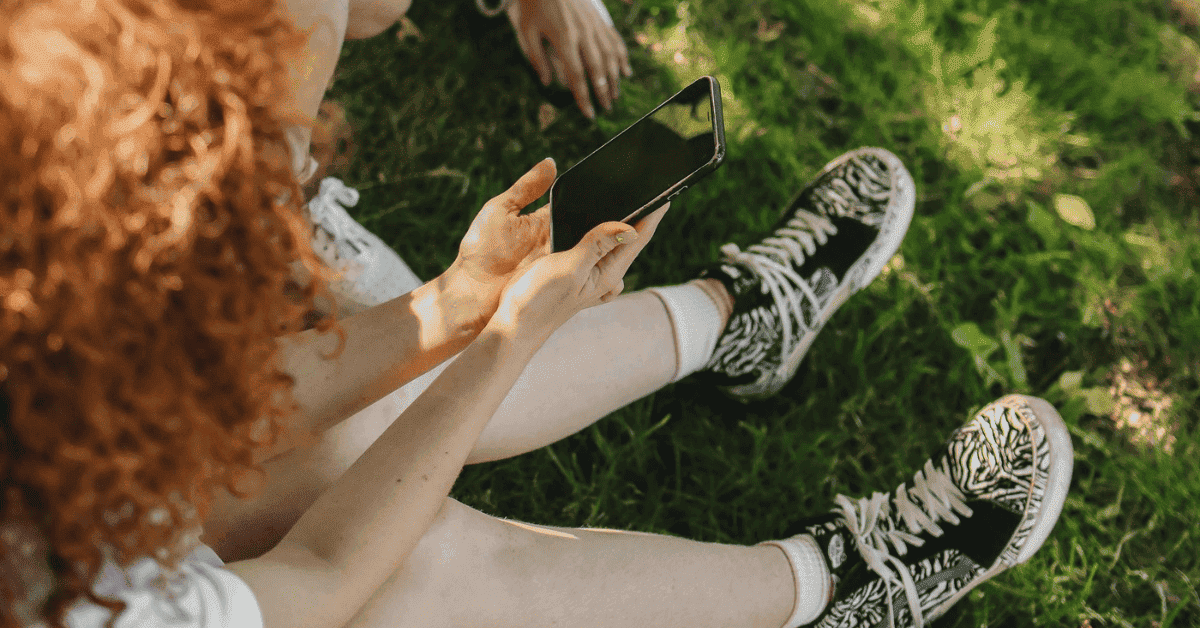 Una adolescente sosteniendo un móvil.
