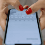 Una persona utilizando un móvil para escribir un comentario