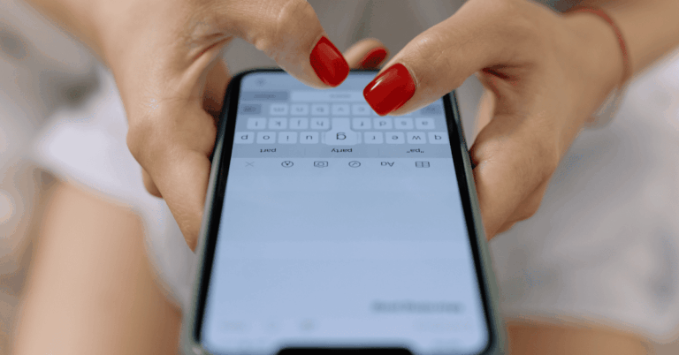 Una persona utilizando un móvil para escribir un comentario
