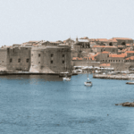 Imagen veraniega de un puerto y un castillo