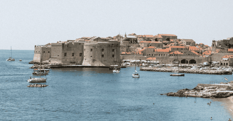 Imagen veraniega de un puerto y un castillo