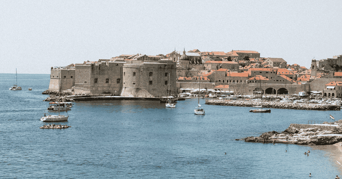 Imagen veraniega de un puerto y un castillo